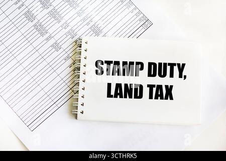 SDLT - droit de timbre, taxe foncière, concept de texte sur une feuille avec un cahier et calculs comptables Banque D'Images