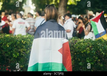 Une jeune femme caucasienne proteste lors d'une manifestation portant le drapeau palestinien - solidarité et marche contre le génocide concept - Focus sur la tête Banque D'Images
