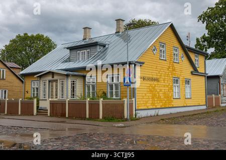 Kuressaare, Saaremaa, Estonie – 25 août 2021 : bâtiment en bois jaune Villa Silbernagel avec un toit en métal et des fenêtres blanches après la pluie. Banque D'Images