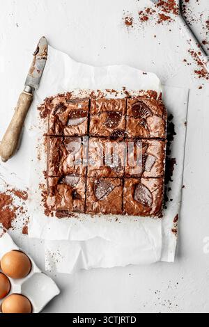 Brownies au chocolat fraîchement cuits coupés en carrés, capturés dans une lumière naturelle douce pour les thèmes de la photographie de boulangerie et de dessert. Banque D'Images
