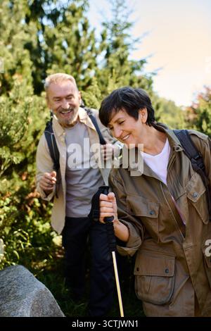 Un couple de personnes âgées explore la beauté de la nature tout en faisant de la randonnée par une journée ensoleillée. Banque D'Images