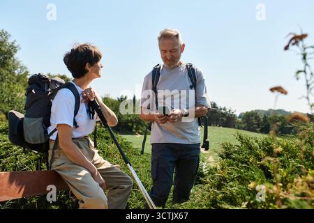Un couple de personnes âgées aime leur randonnée, en profitant de la vue magnifique et en partageant des moments ensemble. Banque D'Images