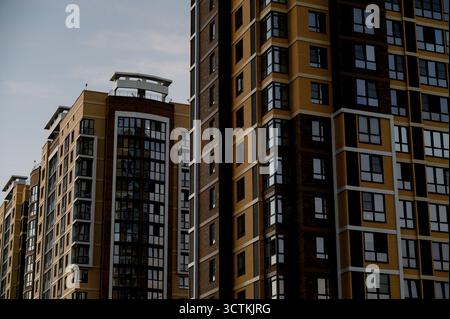 Gros plan des façades de deux immeubles d'appartements modernes avec vitrage. Architecture moderne de bâtiments à plusieurs étages contre le ciel gris de la ville Banque D'Images