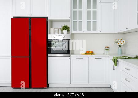 Réfrigérateur rouge et meubles dans la cuisine spacieuse Banque D'Images