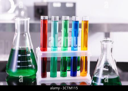 Tubes à essai et autres verreries avec différents liquides colorés sur la table en laboratoire, gros plan Banque D'Images