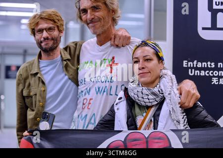 Orly, France. 07 octobre 2025. Les militants qui naviguaient à bord de navires de la flottille humanitaire à destination de Gaza avant d’être arrêtés et détenus par les forces israéliennes, éclairent le signe de paix alors qu’ils sont accueillis par une foule de partisans dans la zone des arrivées de l’aéroport d’Orly, dans la banlieue de Paris, en France, le 7 octobre 2025. Photo de Karim ait Adjedjou/ABACAPRESS.COM crédit : Abaca Press/Alamy Live News Banque D'Images