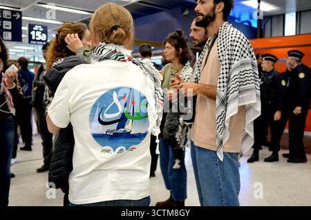 Orly, France. 07 octobre 2025. Ambiance à l’arrivée des militants qui naviguaient à bord de navires de la flottille humanitaire à destination de Gaza avant d’être arrêtés et détenus par les forces israéliennes, éclair le signe de paix alors qu’ils sont accueillis par une foule de partisans dans la zone des arrivées de l’aéroport d’Orly, en périphérie de Paris, en France, le 7 octobre 2025. Photo de Karim ait Adjedjou/ABACAPRESS.COM crédit : Abaca Press/Alamy Live News Banque D'Images