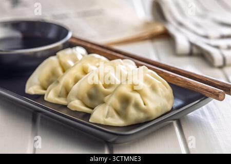 Boulettes gyoza japonaises traditionnelles sur assiette sur une table blanche. Banque D'Images