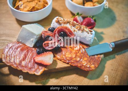 Panneau de charcuterie présentant un assortiment de fromages, salami, chorizo, fruits, noix, et des craquelins Banque D'Images