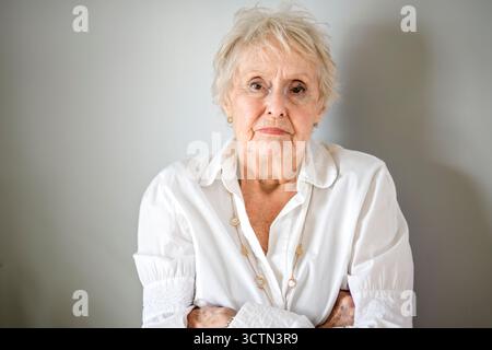 Belle femme âgée en colère devant un fond blanc Banque D'Images