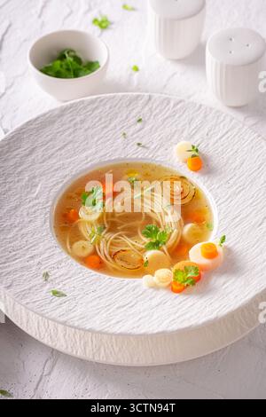 Soupe de bouillon professionnelle comme nourriture de haute qualité dans un restaurant sophistiqué. Soupe de bouillon avec une décoration exquise. Banque D'Images