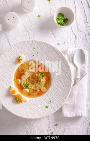 Soupe de bouillon élégante comme plat fin élégant et de bon goût. Soupe de bouillon avec une décoration exquise. Banque D'Images