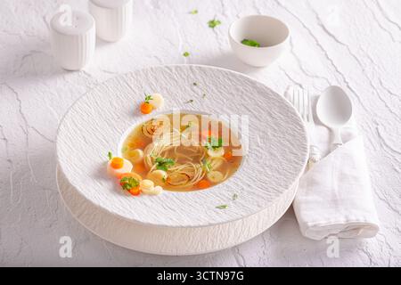Soupe de bouillon élégante comme nourriture de première qualité faite dans le restaurant. Soupe de bouillon avec une décoration exquise. Banque D'Images