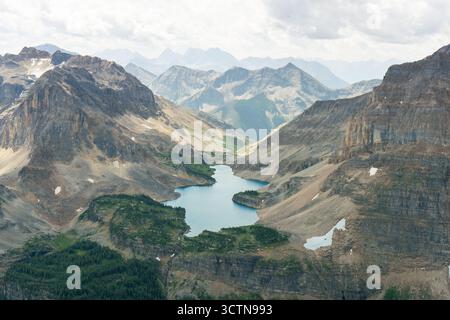 Vue aérienne panoramique d'un lac turquoise niché entre des montagnes majestueuses. Banque D'Images