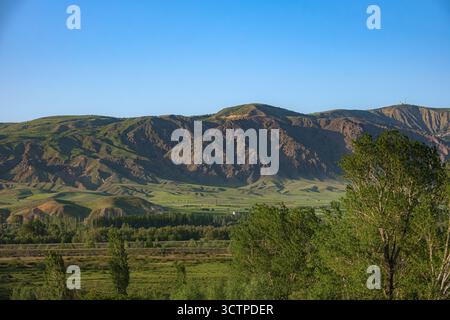 Vue pittoresque sur les montagnes vallonnées et les vallées verdoyantes sous un ciel bleu clair. Montagnes dans le lointain. Banque D'Images