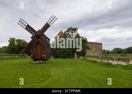 Kuressaare, Saaremaa, Estonie – 25 août 2021 : moulin à vent traditionnel en bois debout sur une pelouse verte près du château historique de Kuressaare. Banque D'Images