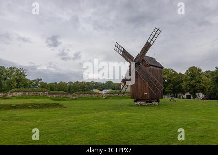 Kuressaare, Saaremaa, Estonie – 25 août 2021 : moulin à vent traditionnel en bois debout sur une pelouse verte près du château historique de Kuressaare. Banque D'Images