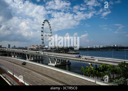 Singapore City, Singapour - 27 février 2025 : paysage urbain avec une grande autoroute et un célèbre Singapore Flyer, l'un des monuments de la ville. Banque D'Images
