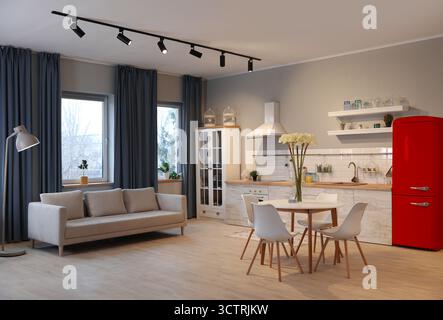 Réfrigérateur rouge, canapé et table à manger avec chaises dans un appartement spacieux Banque D'Images