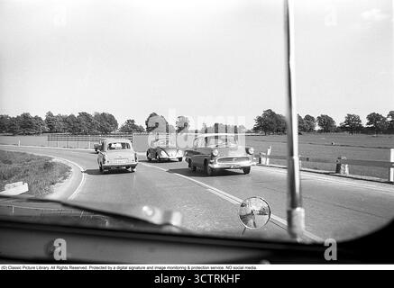 Surveillance de la circulation policière sur Riksetan, 1958. Entre 1945 et 1962, la Riksväg 1 a servi de route principale reliant Helsingborg à Stockholm. Aujourd'hui, cette route fait partie de la route européenne E4. Une vue depuis un véhicule de police surveillant la circulation sur la route achalandée. Suède, 1958. Dans les années 1950, alors que le trafic automobile augmentait sur le réseau routier suédois en pleine expansion, les patrouilles de police jouaient un rôle crucial pour assurer la sécurité routière et l’application de la loi. Roland Palm réf. 3/533. Banque D'Images