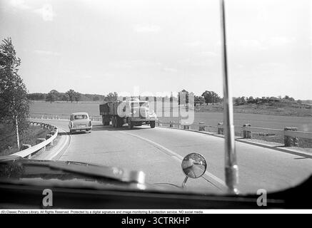 Surveillance de la circulation policière sur Riksetan, 1958. Entre 1945 et 1962, la Riksväg 1 a servi de route principale reliant Helsingborg à Stockholm. Aujourd'hui, cette route fait partie de la route européenne E4. Une vue depuis un véhicule de police surveillant la circulation sur la route achalandée. Suède, 1958. Dans les années 1950, alors que le trafic automobile augmentait sur le réseau routier suédois en pleine expansion, les patrouilles de police jouaient un rôle crucial pour assurer la sécurité routière et l’application de la loi. Roland Palm réf. 3/533. Banque D'Images