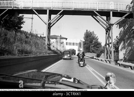 Surveillance de la circulation policière sur Riksetan, 1958. Entre 1945 et 1962, la Riksväg 1 a servi de route principale reliant Helsingborg à Stockholm. Aujourd'hui, cette route fait partie de la route européenne E4. Une vue depuis un véhicule de police surveillant la circulation sur la route achalandée. Un policier moto sur une moto BMW est à l'avant. Suède, 1958. Dans les années 1950, alors que le trafic automobile augmentait sur le réseau routier suédois en pleine expansion, les patrouilles de police jouaient un rôle crucial pour assurer la sécurité routière et l’application de la loi. Roland Palm réf. 3/533. Banque D'Images