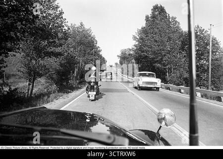 Surveillance de la circulation policière sur Riksetan, 1958. Entre 1945 et 1962, la Riksväg 1 a servi de route principale reliant Helsingborg à Stockholm. Aujourd'hui, cette route fait partie de la route européenne E4. Une vue depuis un véhicule de police surveillant la circulation sur la route achalandée. Un policier moto sur une moto BMW est à l'avant. Suède, 1958. Dans les années 1950, alors que le trafic automobile augmentait sur le réseau routier suédois en pleine expansion, les patrouilles de police jouaient un rôle crucial pour assurer la sécurité routière et l’application de la loi. Roland Palm réf. 3/533. Banque D'Images