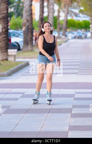 Femme patin à roulettes sur la rue de la ville en plein air style de vie d'été loisirs actifs Banque D'Images
