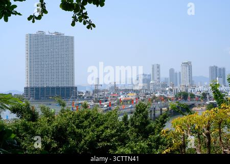NHA TRANG, VIETNAM - 25 AVRIL 2025. Vue sur la ville avec un pont sur la rivière Cai, gratte-ciel et grues de construction Banque D'Images