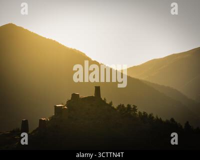 Vue aérienne d'anciennes tours de pierre perçant la lumière dorée sur fond de montagnes vallonnées, Upper Omalo, Kakheti, géorgie. Banque D'Images