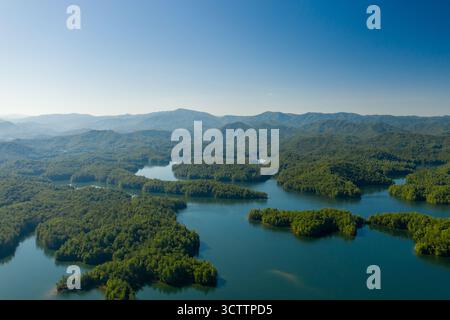Vue aérienne des îles boisées nichées dans un lac serein, reflétant le ciel clair, entouré de montagnes lointaines et brumeuses, créant un panorama tranquille, Géorgie, États-Unis. Banque D'Images