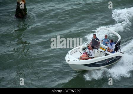 Venise. Italie - 08 octobre 2025 : un groupe de quatre personnes de différents âges profite d'une excursion en bateau à moteur sur la lagune vénitienne, une activité populaire en VE Banque D'Images