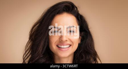 Femme souriante avec de beaux cheveux met en valeur la confiance dans un fond de collage aux tons chauds Banque D'Images