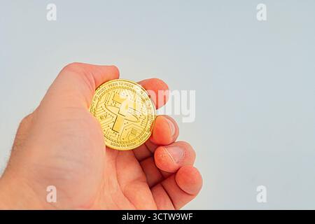 L'image montre un gros plan d'une main tenant une pièce de monnaie d'attache physique, avec le symbole BTC sur sa pièce de monnaie d'attache a de conception Banque D'Images