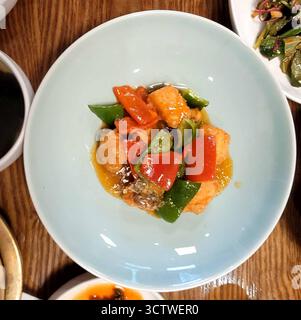 Une photographie de la cuisine coréenne traditionnelle, en particulier un plat de poisson aigre-doux ou de tofu avec des poivrons rouges et verts, servi à Gyeongju, en Corée du Sud. Cuisine coréenne, ou ? ? (Hansik), est réputé pour son utilisation d'ingrédients fermentés et de produits frais. 2025. Banque D'Images