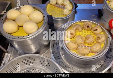 Une photographie de la cuisine coréenne traditionnelle, spécifiquement cuite à la vapeur ? ? (jjinppang) et ? ? (mandu), préparé dans des vapeurs métalliques à Gyeongju, Corée du Sud. Les Jjinppang sont souvent remplis de pâte de haricots rouges sucrés et sont une nourriture de rue ou une collation appréciée en Corée. 2025. Banque D'Images