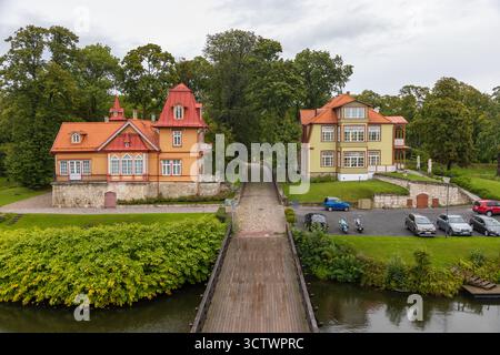 Kuressaare, Saaremaa, Estonie – 25 août 2021 : Villas restaurées en bois aux toits rouges situées près des douves près du château de Kuressaare entourées de verdure Banque D'Images