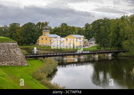 Kuressaare, Saaremaa, Estonie – 25 août 2021 : bâtiment historique jaune et pont en bois sur les douves près du complexe du château de Kuressaare. Banque D'Images