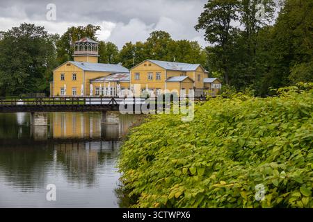 Kuressaare, Saaremaa, Estonie – 25 août 2021 : bâtiment historique jaune et pont en bois sur les douves près du complexe du château de Kuressaare. Banque D'Images