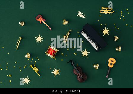 Motif unique fait de divers instruments de musique et confettis d'étoile de paillettes dorées sur fond vert. Concept de Noël et nouvel an. Banque D'Images
