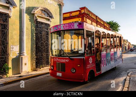 Campeche, Mexique - bus rouge avec un logo rose et blanc sur le côté. Le bus est garé dans une rue devant un bâtiment Banque D'Images