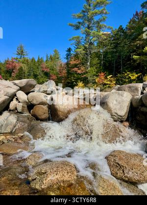Les eaux de la rivière Swift se précipitent sur les rochers de granit lors d'une belle journée de fin septembre dans la forêt nationale de White Mountain. Banque D'Images