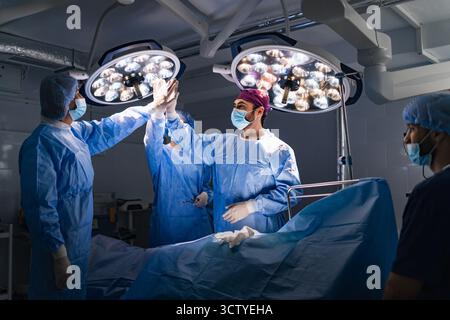 Chirurgiens High-Five en salle d'opération Banque D'Images