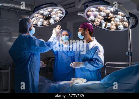 Chirurgiens High-Five en salle d'opération Banque D'Images