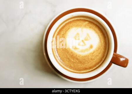 Café cappuccino mousseux avec Jack O' Lantern Latte Art Banque D'Images
