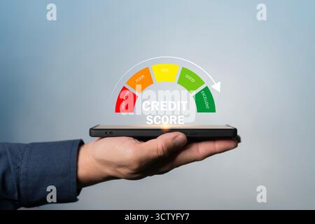 Main tenant smartphone avec indicateur de cote de crédit montrant les performances financières, représentant les finances personnelles, l'éligibilité au prêt, le risque bancaire ev Banque D'Images