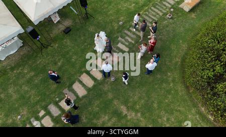 Piacenza, Italie - 7 septembre 2025 les nouveaux mariés dansent ensemble pour la première fois, entourés d'êtres chers dans un magnifique jardin à un ch Banque D'Images