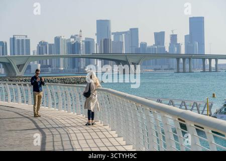 Couple de touristes à la promenade de corniche à Abu Dhabi, Émirats arabes Unis, un lieu touristique. Banque D'Images