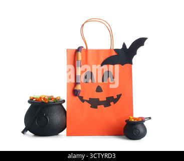 Sac en papier, chaudrons et délicieux bonbons à la gelée d'Halloween isolés sur fond blanc Banque D'Images
