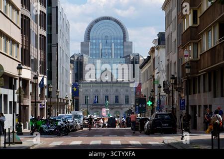Des personnes et des voitures devant le bâtiment du Parlement européen vu à travers une rue animée le 20 mai 2025 à Bruxelles, Belgique. Banque D'Images
